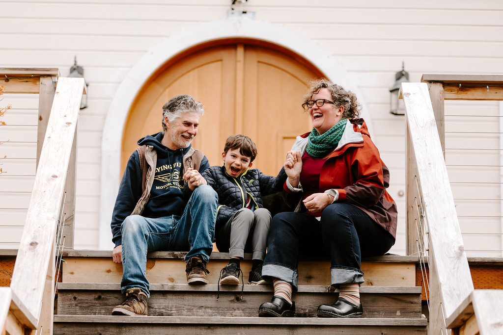 John, Clyde and Erin Telford, winners of the contest, sitting on the front steps outside of their home on SE 62nd Ave